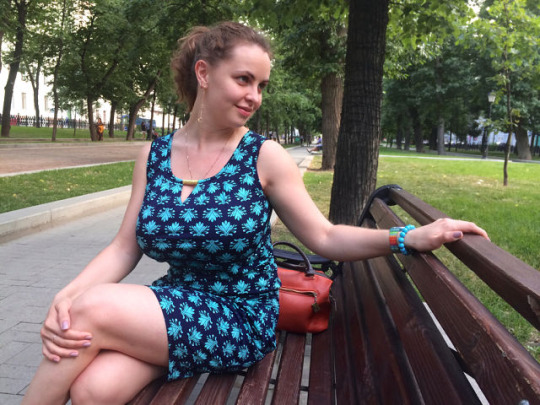 busty brunette on a park bench